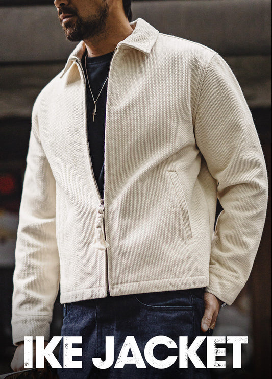 A man wearing an off-white textured zip-up jacket with a collar and front pockets, paired with a black t-shirt and dark blue jeans. The text 'IKE JACKET' is displayed at the bottom of the image.